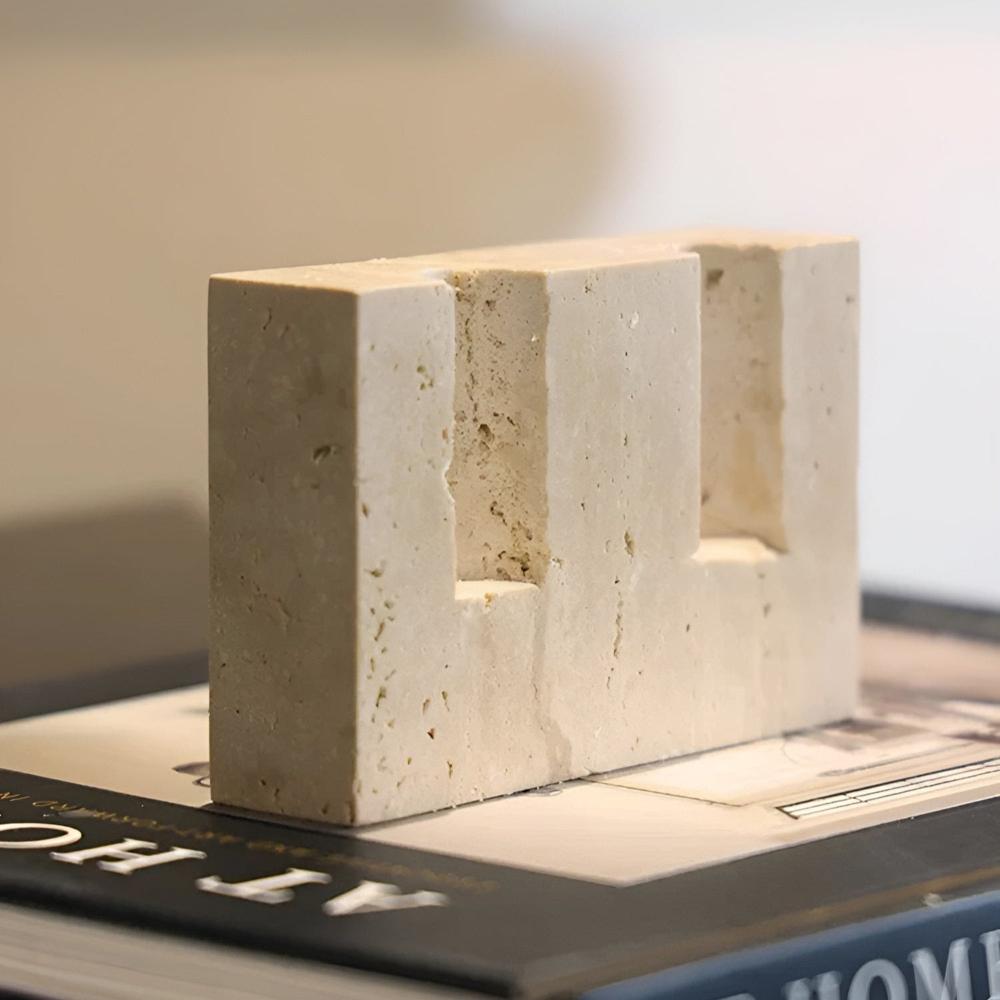 Travertine stone candle stand with two rectangular cutouts for taper candles.