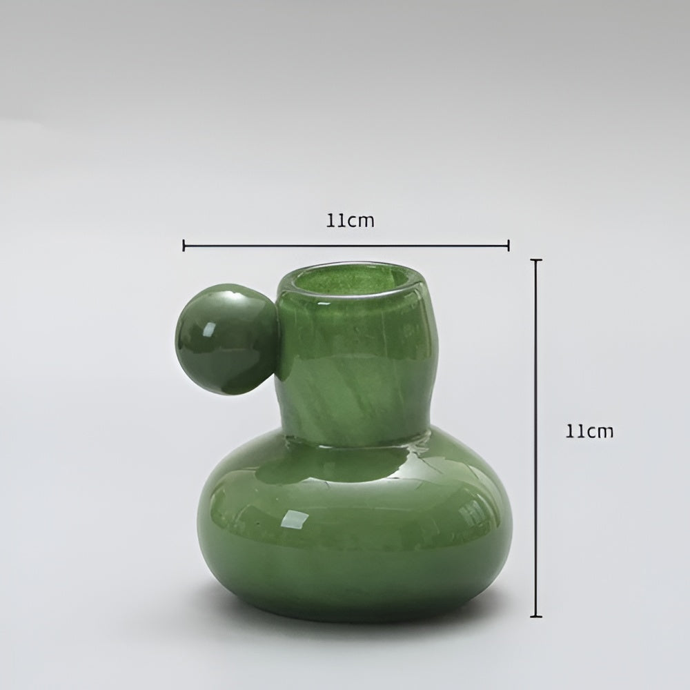 Green glass candle holder with a round ball accent, 11cm wide and 11cm tall.