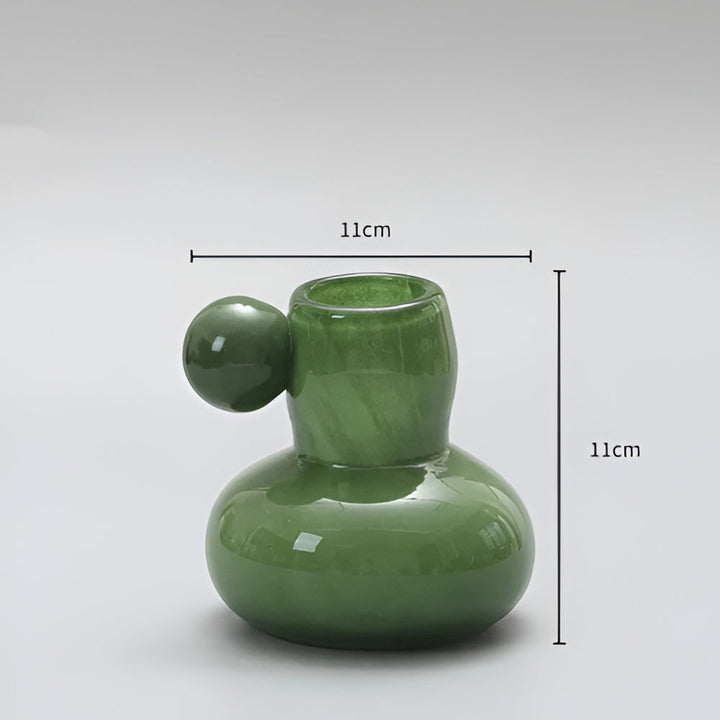 Green glass candle holder with a round ball accent, 11cm wide and 11cm tall.