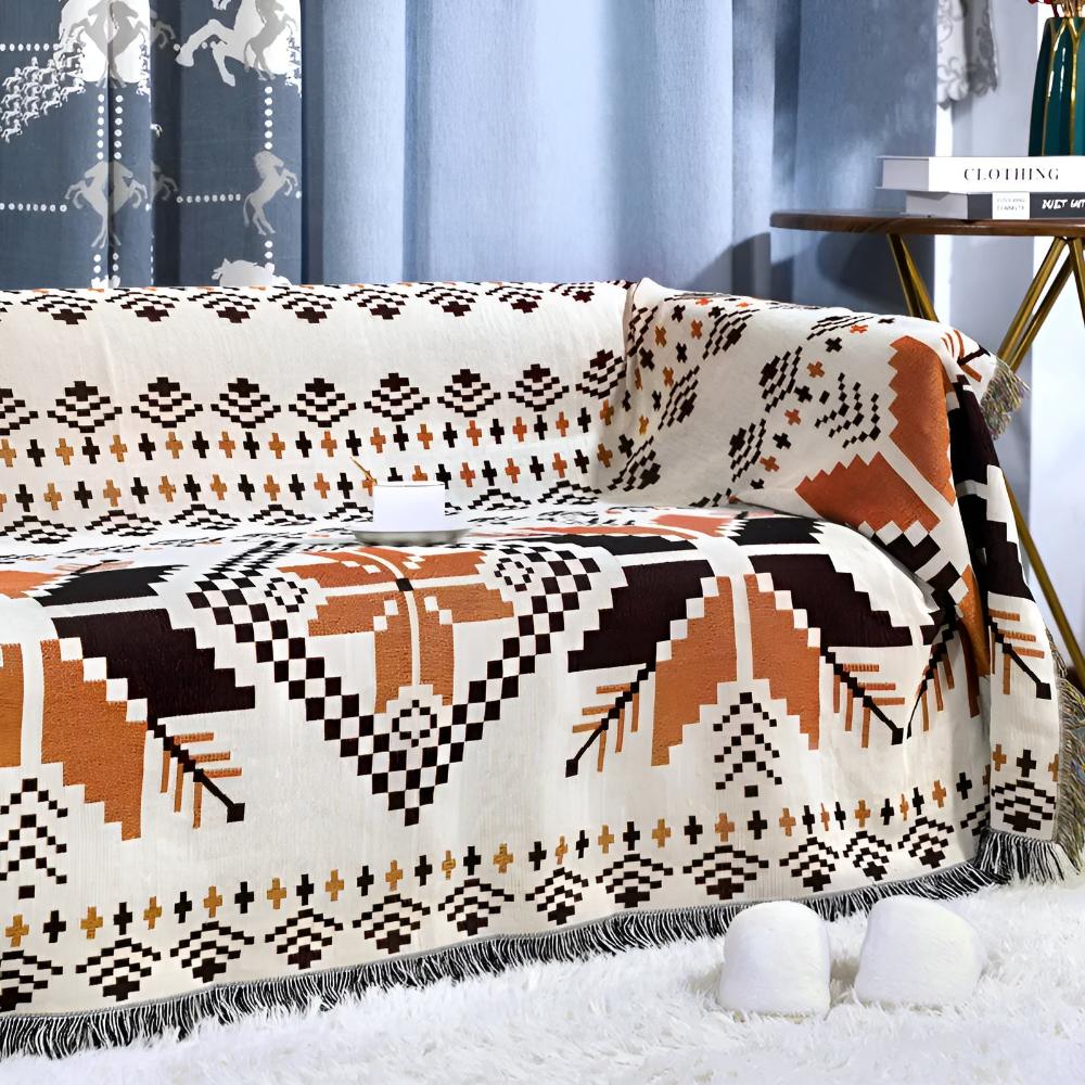 Moroccan boho picnic mat with geometric patterns draped over a sofa.