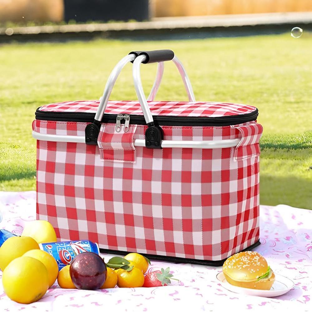 Red and white checkered insulated picnic basket with food and drinks on a blanket.