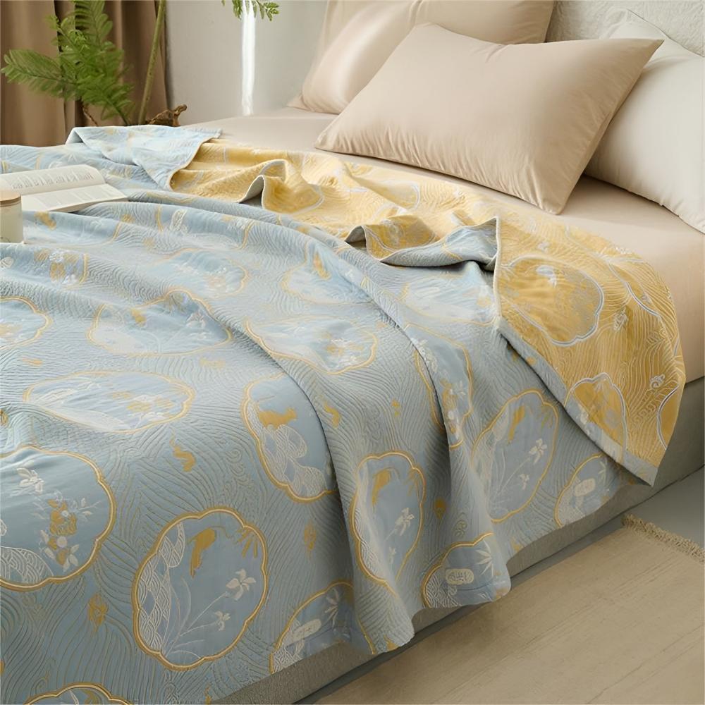 Reversible blanket with a light blue side featuring a cloud and floral pattern and a yellow side with a wave pattern.