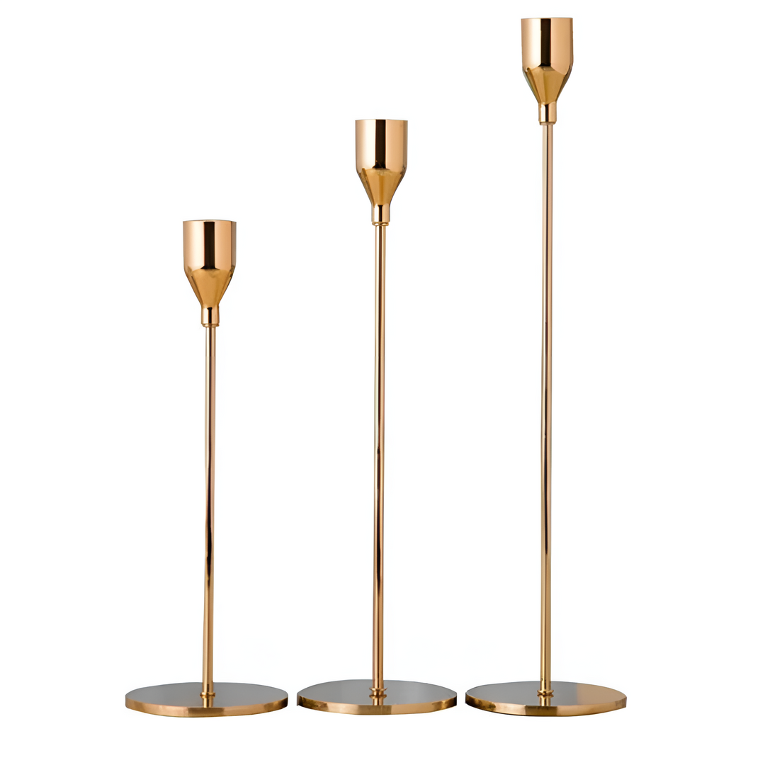 Set of three brushed metal taper candle holders in varying heights.