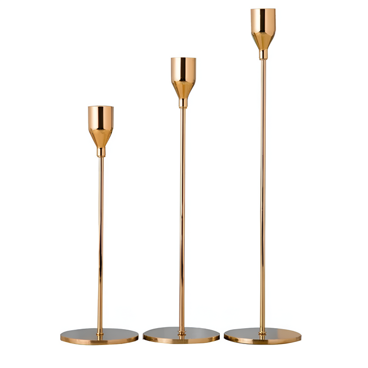 Set of three brushed metal taper candle holders in varying heights.