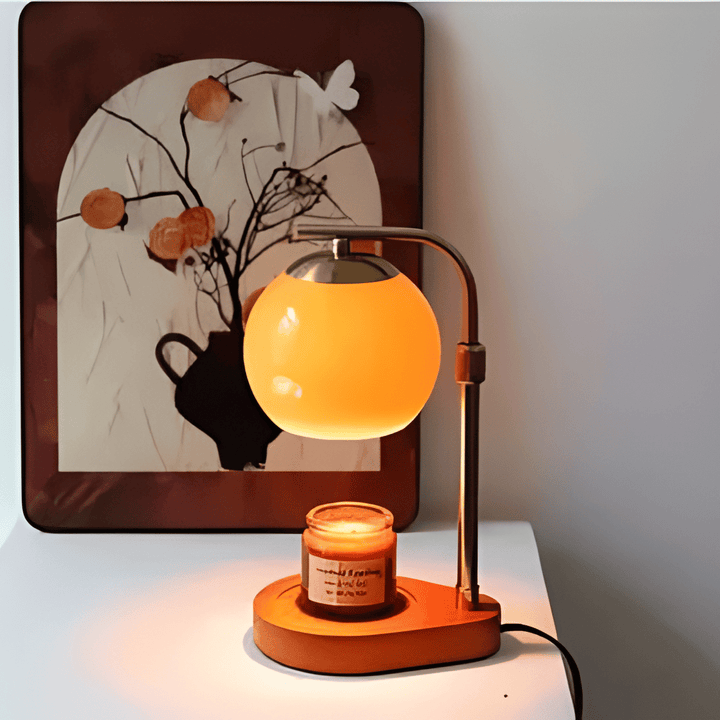 Sculpted glass candle warmer lamp with a retro amber globe and a lit candle on a wooden base.