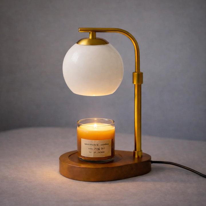 Sculpted glass candle warmer lamp with a white globe shade and a wooden base, melting a candle.