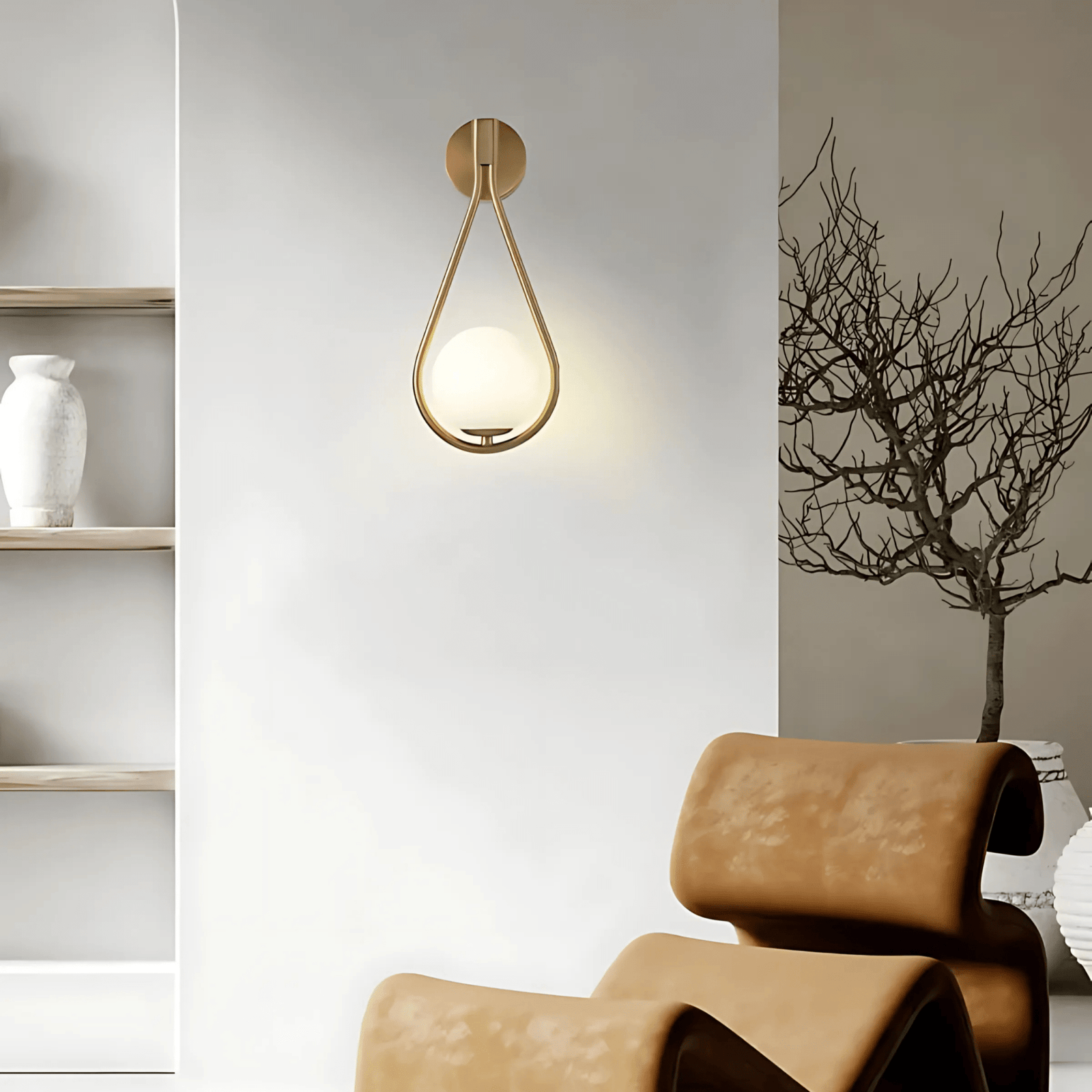 Gold teardrop wall sconce with a frosted glass globe light.