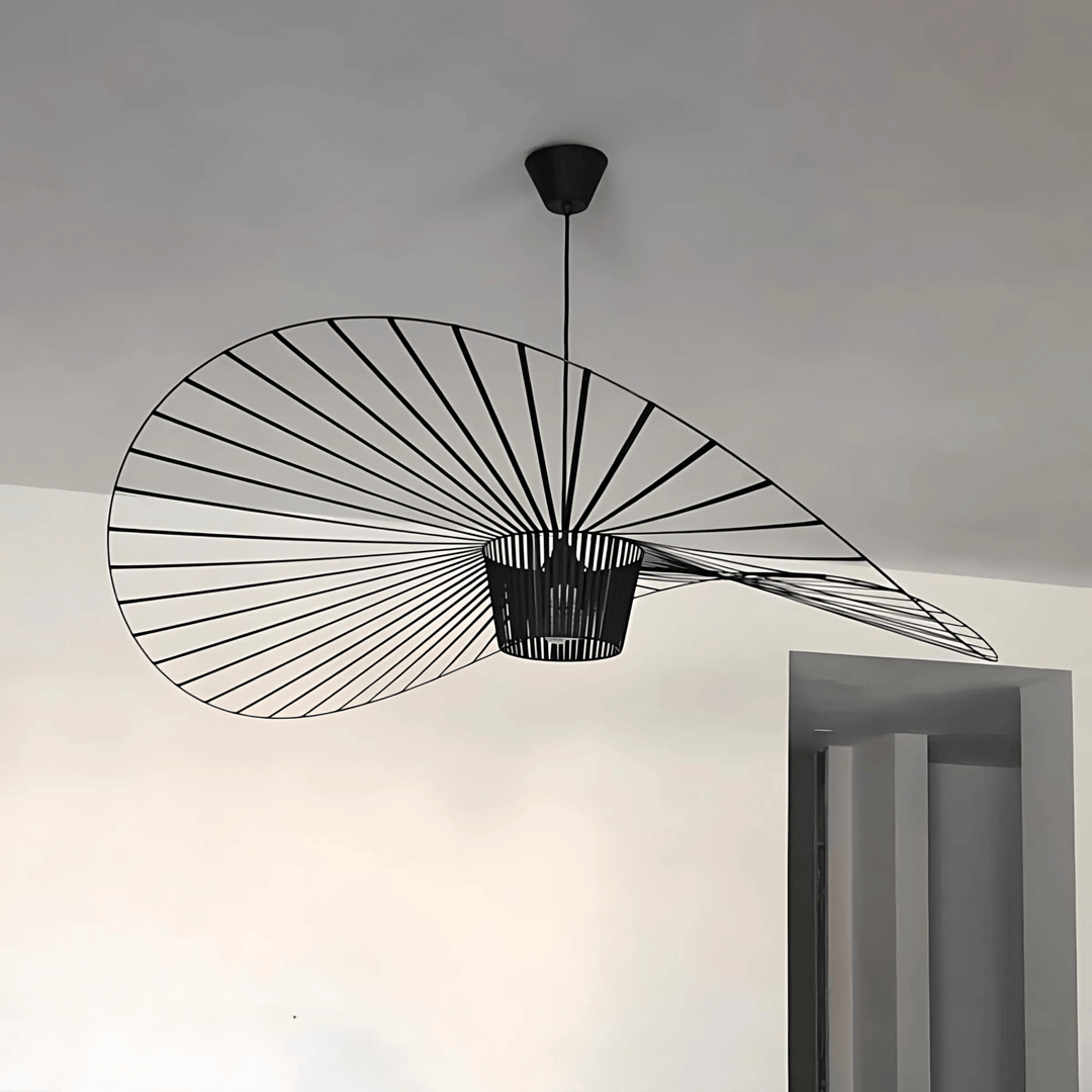 Black wire pendant light with a wide, flat shade resembling a hat, suspended from a black ceiling mount.