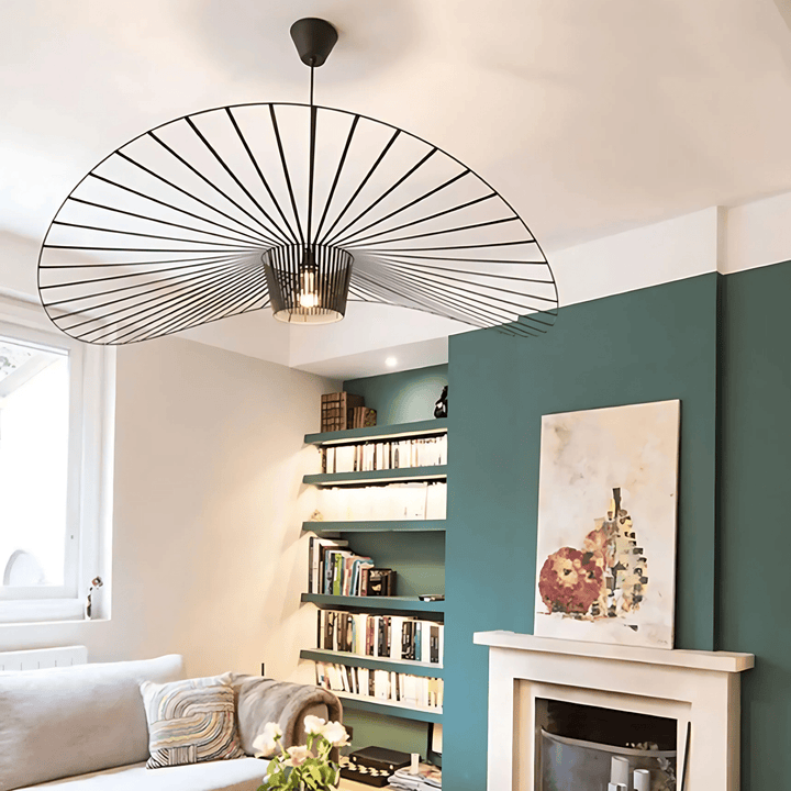 Contemporary pendant light with a black wire frame resembling a fan, illuminating a living room.