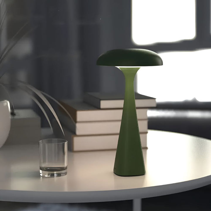 Green Jellyfish Desk Lamp with a soft ambient glow on a white table.