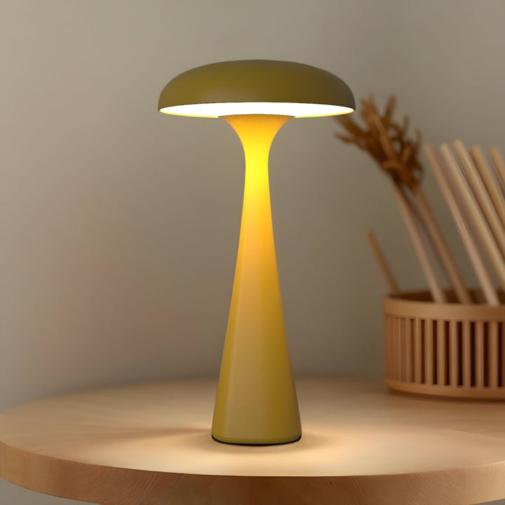 Yellow jellyfish-shaped desk lamp with a soft ambient glow on a wooden table.