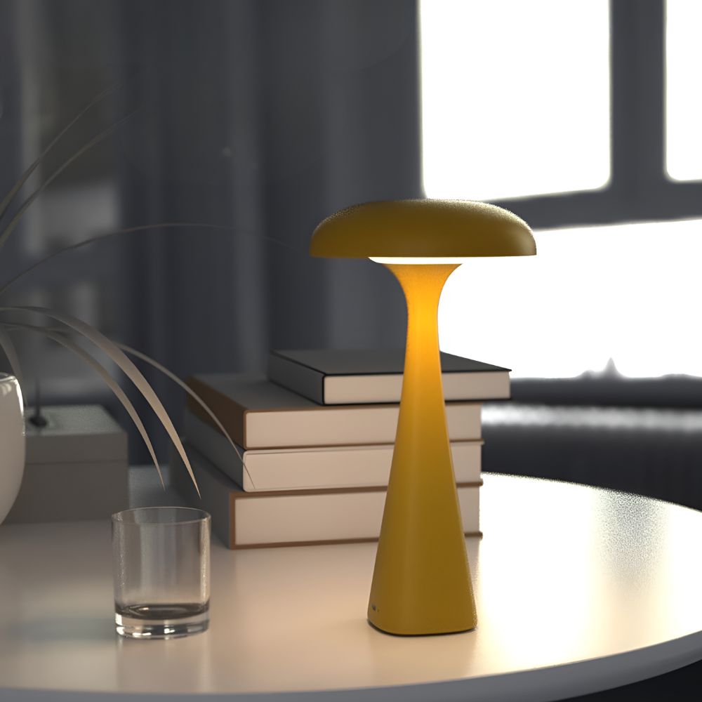 Yellow Jellyfish Desk Lamp with a soft ambient glow on a table with books and a glass.