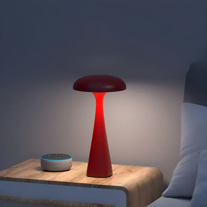 Red jellyfish desk lamp with a soft ambient glow on a nightstand next to a smart speaker.