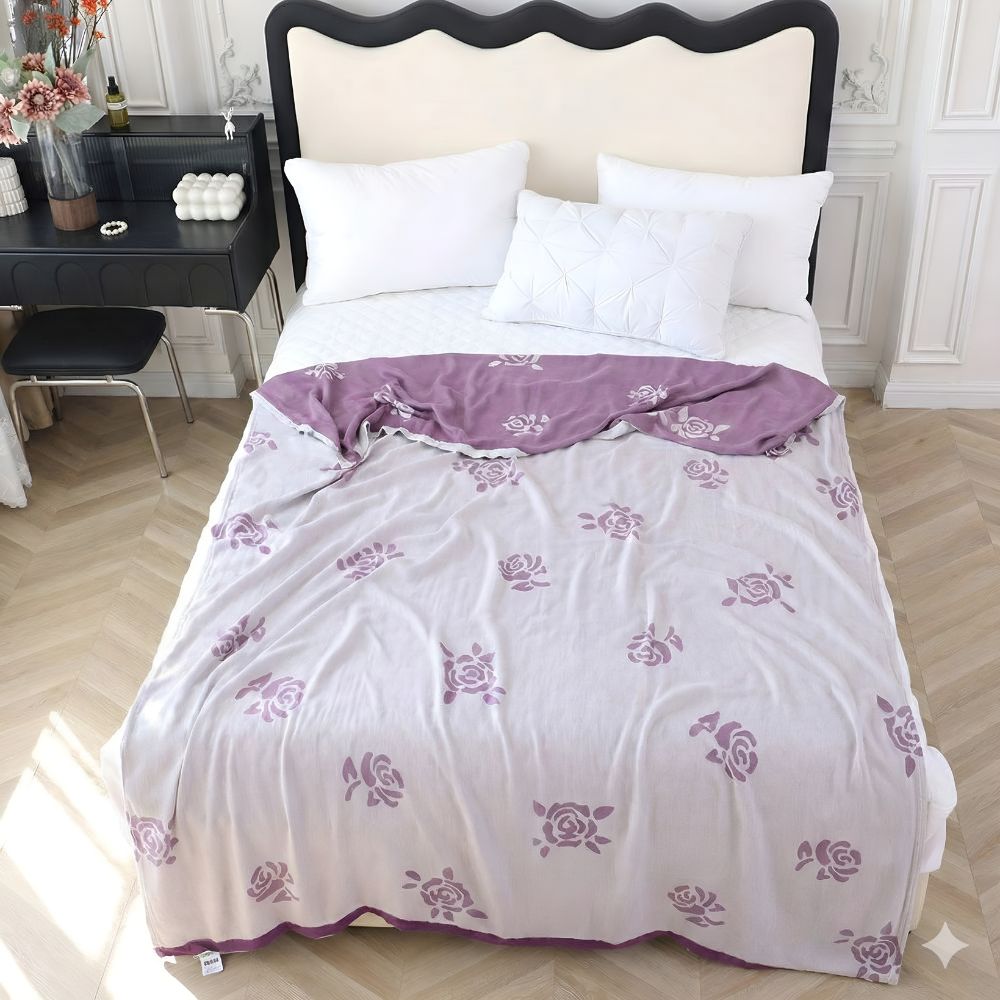 A light purple bamboo fiber cooling blanket with a rose pattern draped on a bed.