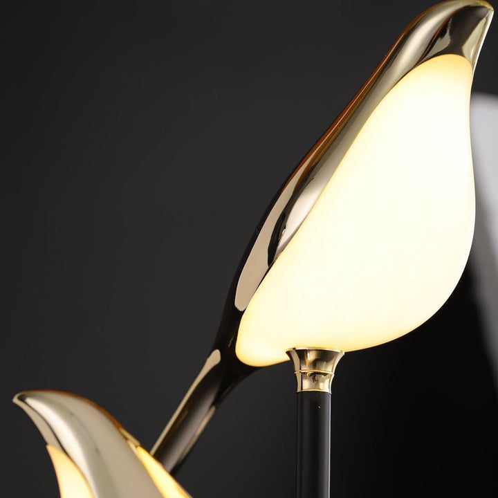Nordic LED wall sconce with a golden bird design emitting a warm light against a dark background.