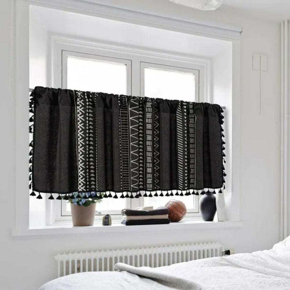 Black linen cabinet curtain with white geometric tribal patterns and black tassel trim.