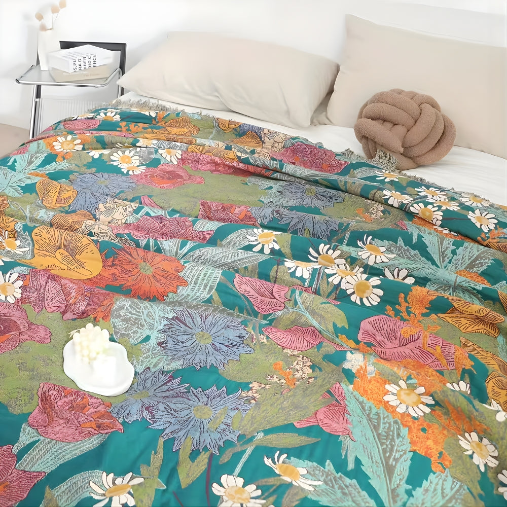 Bohemian floral patchwork tassel blanket with a teal base and colorful flowers.