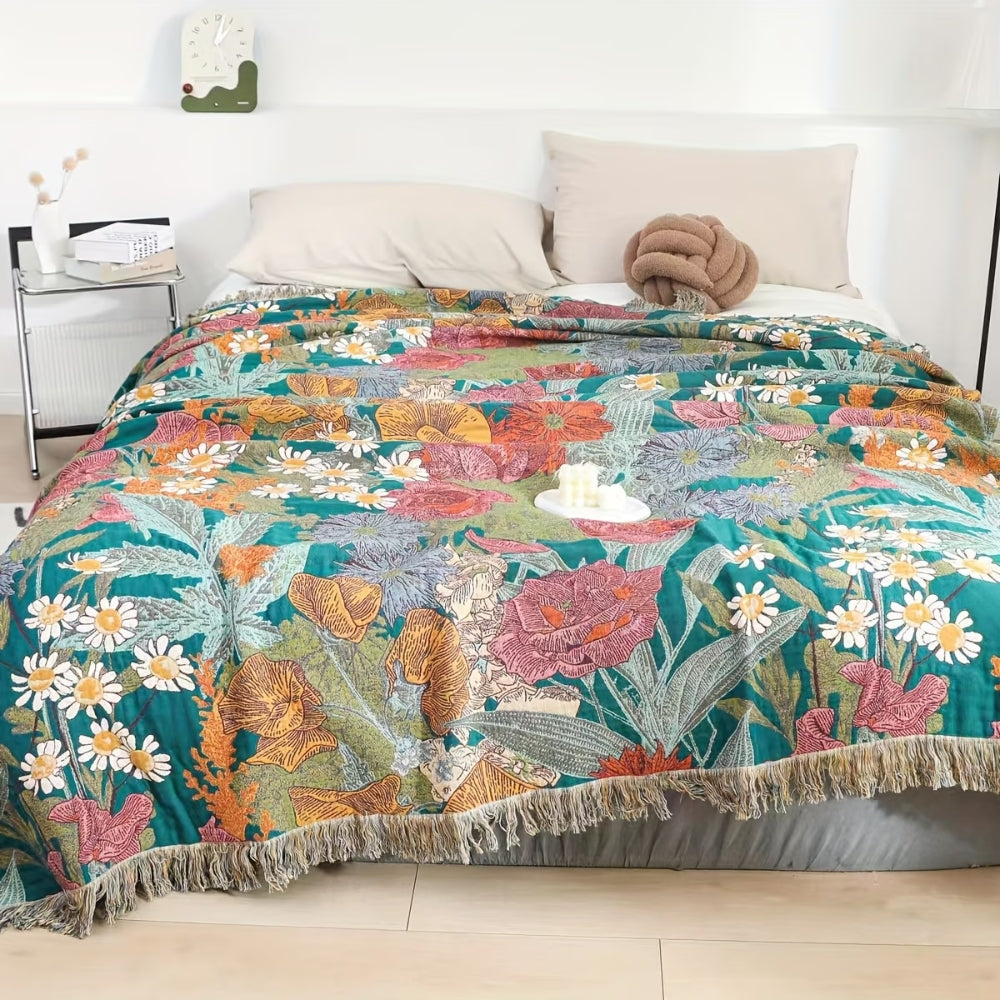 Bohemian floral patchwork tassel blanket with fringe detail on a bed.