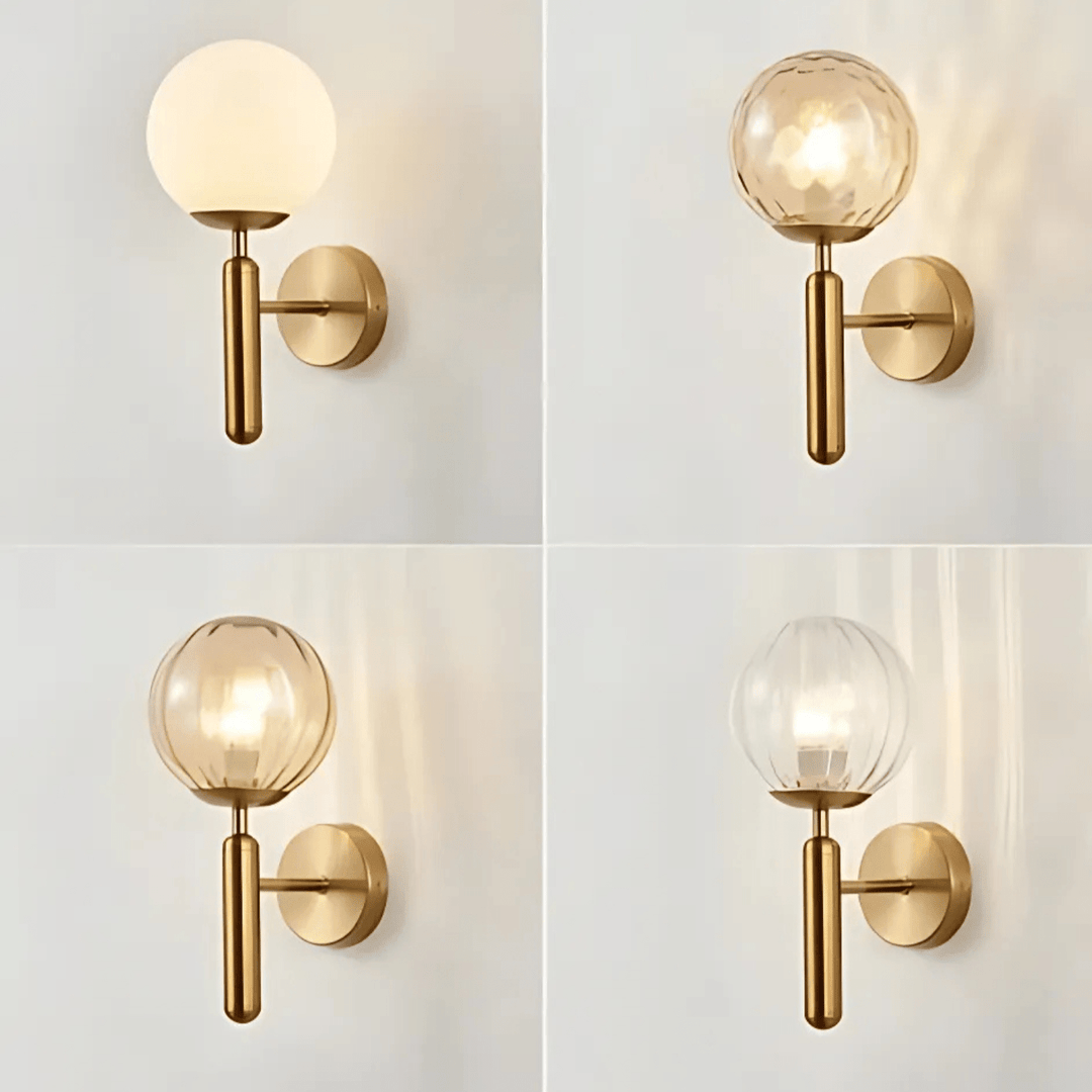 Four brass metal wall sconces with different glass globes: frosted white, amber textured, amber ribbed, and clear ribbed.