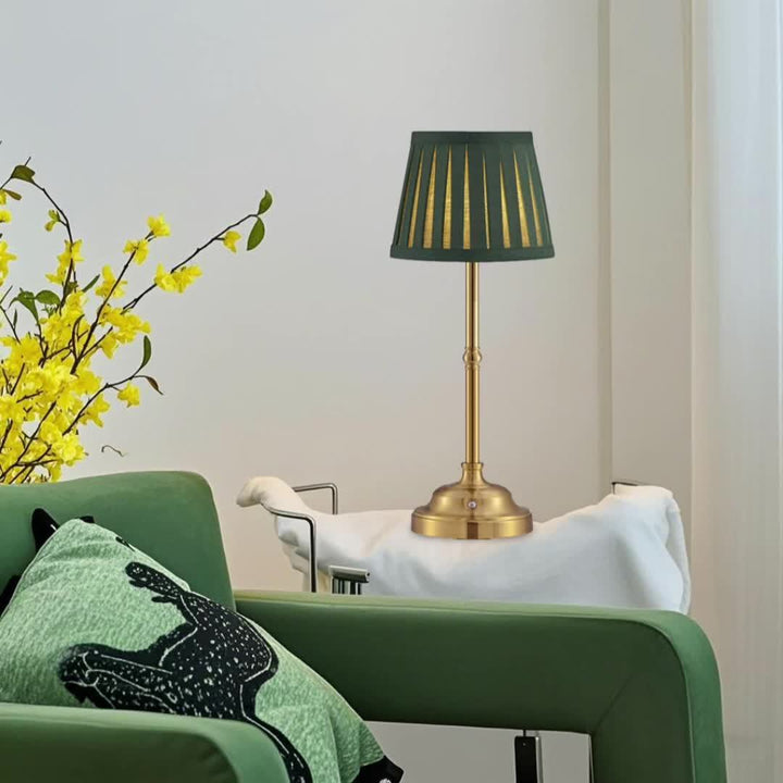 Brass finish cordless rechargeable table lamp with a dark green pleated shade.