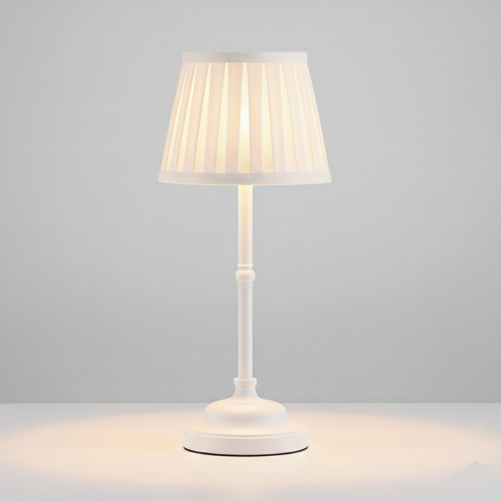 White cordless rechargeable table lamp with a pleated shade and a touch-sensitive base.