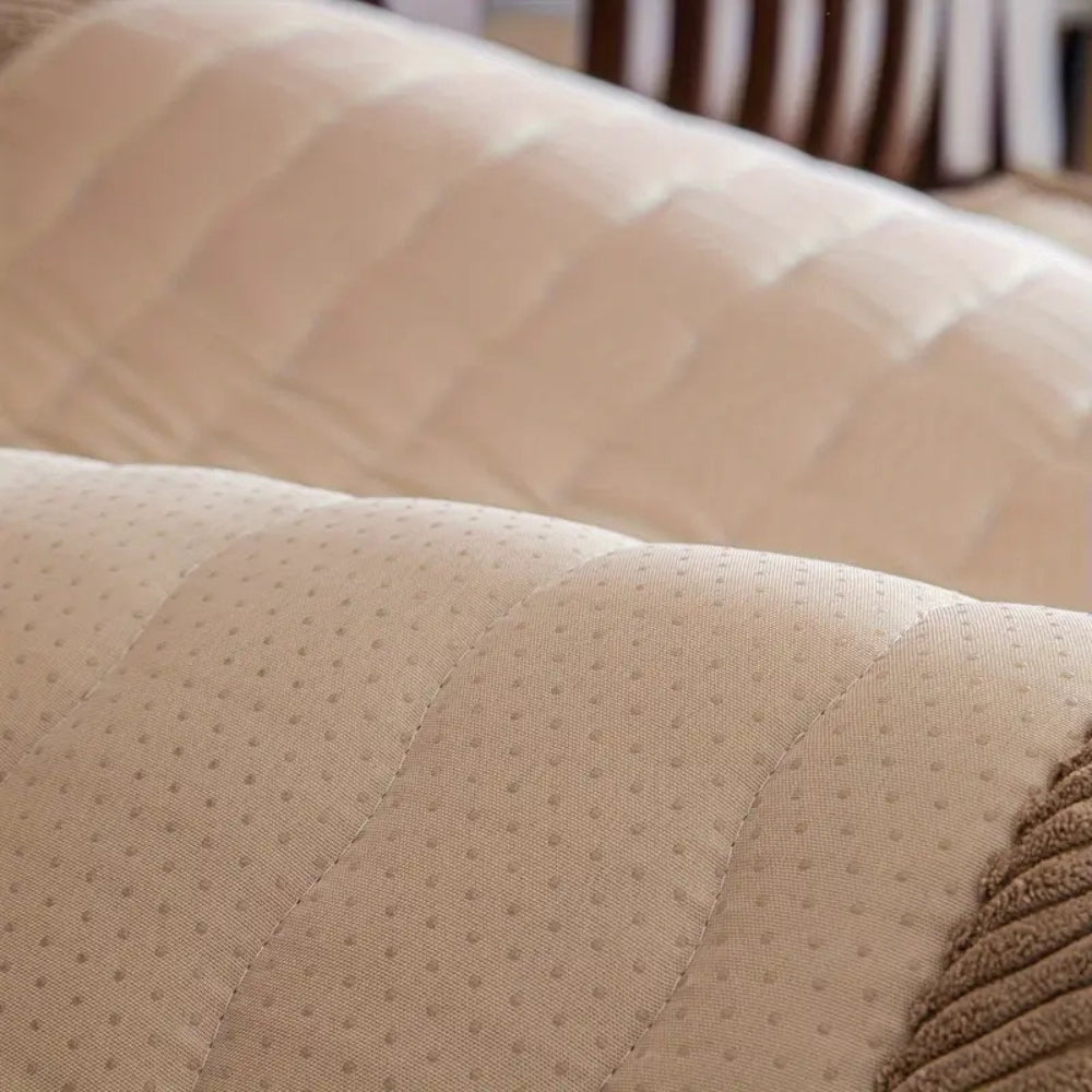 Close-up of a beige plush sofa cover with a non-slip dotted backing and corduroy trim.