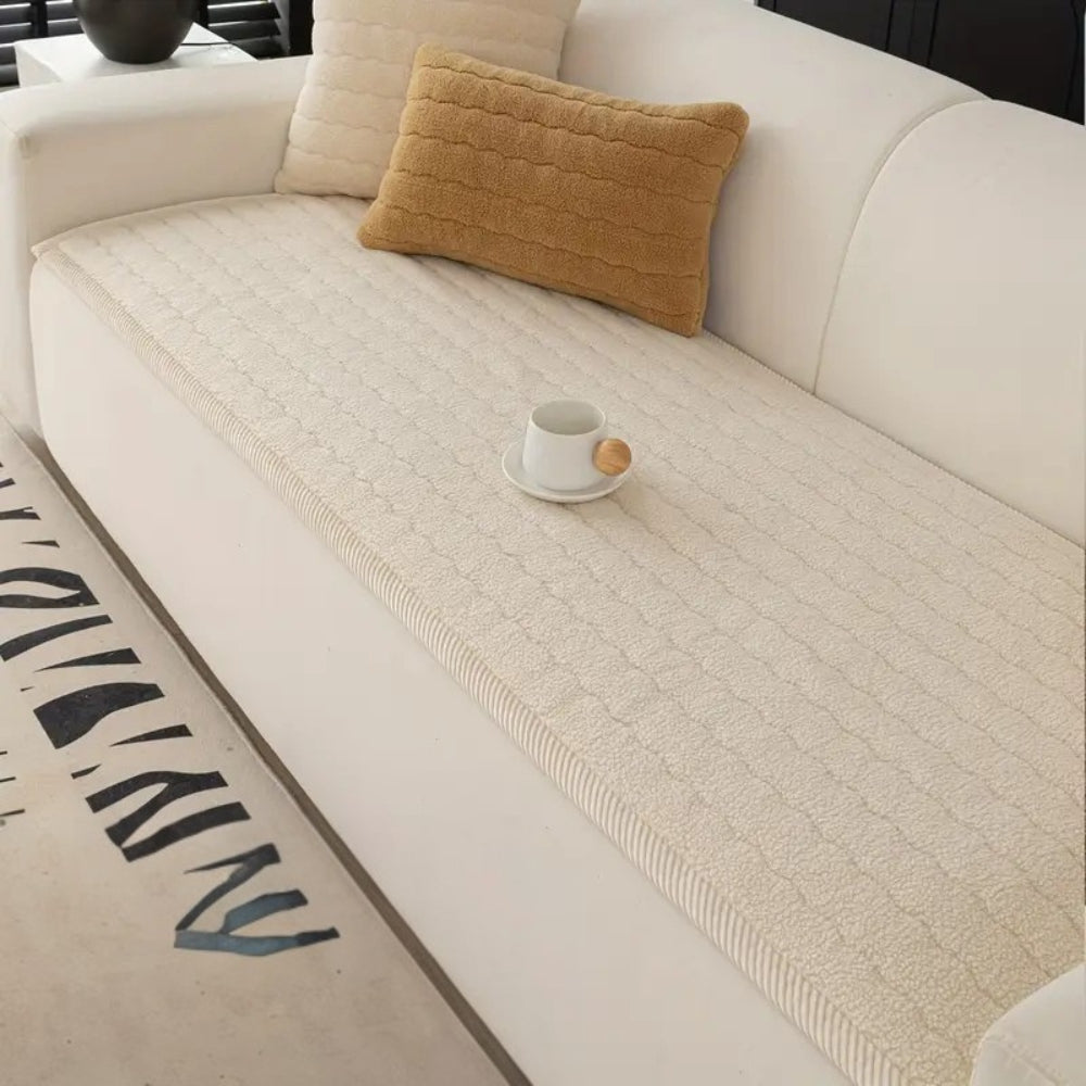 Cream plush sofa cover with a textured pattern, featuring a white mug on a saucer.