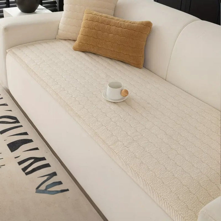 Cream plush sofa cover with a textured pattern, featuring a white mug on a saucer.