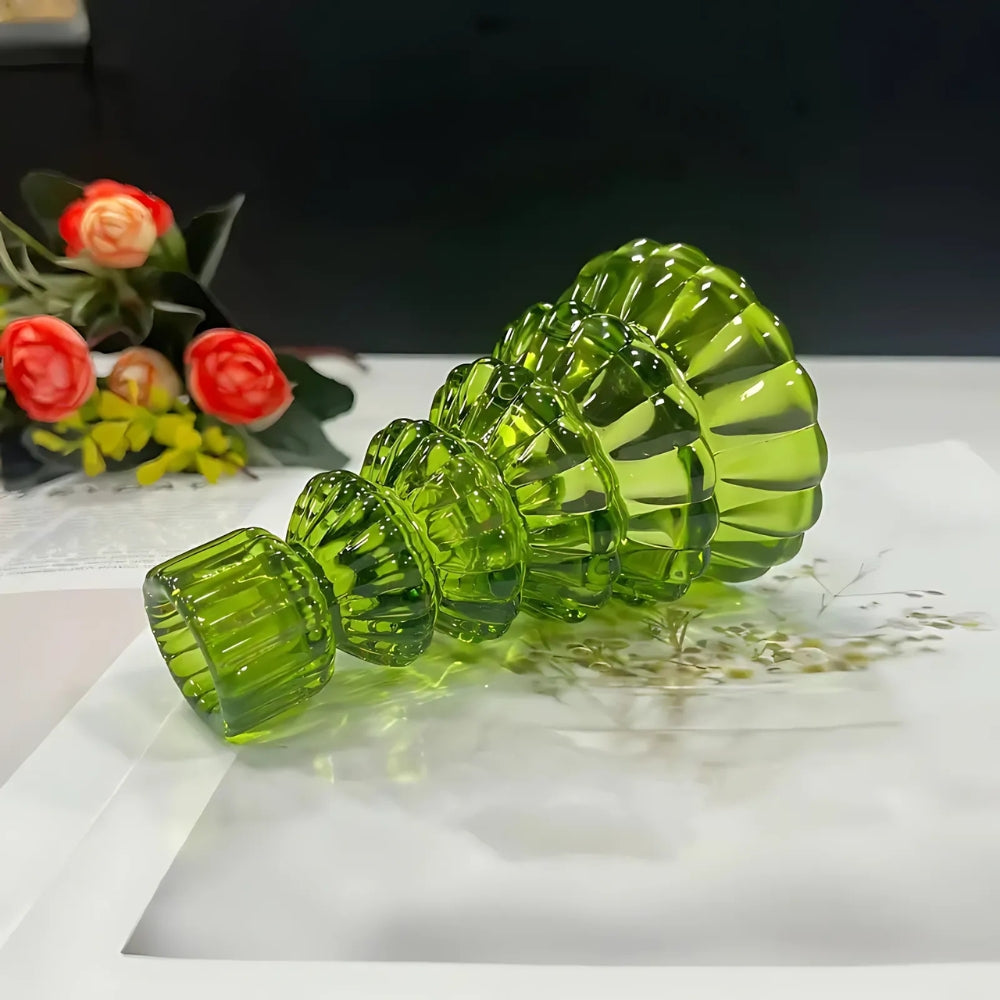 Set of three green glass Christmas tree candle holders arranged in a row, decreasing in size.