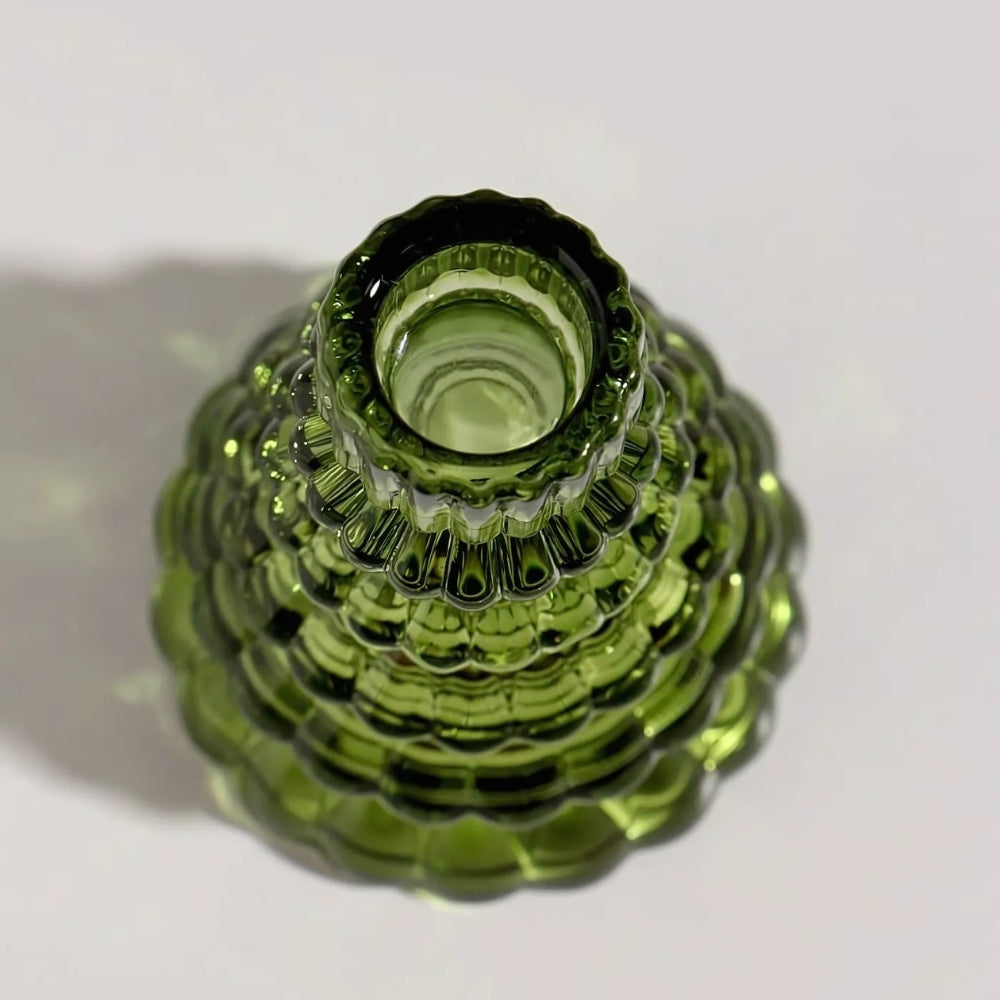 Green glass Christmas tree candle holder with textured surface, viewed from above.