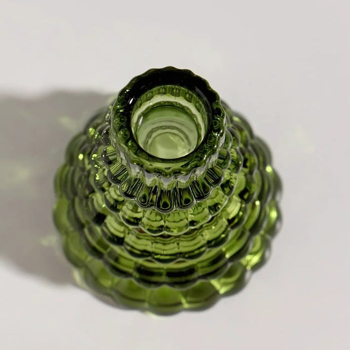 Green glass Christmas tree candle holder with textured surface, viewed from above.
