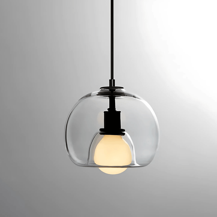 Clear handblown glass pendant light with a black fixture and a warm white bulb.
