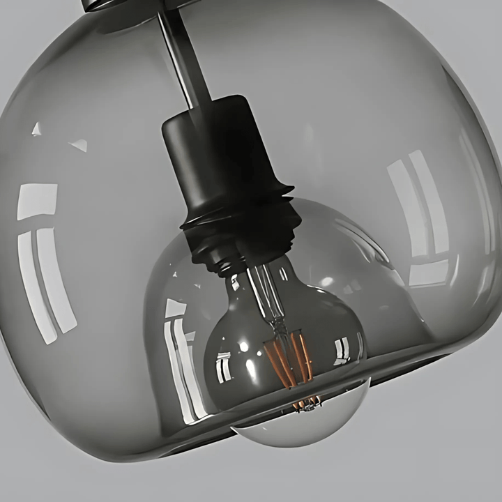 Smoked grey handblown glass pendant light with exposed filament bulb.