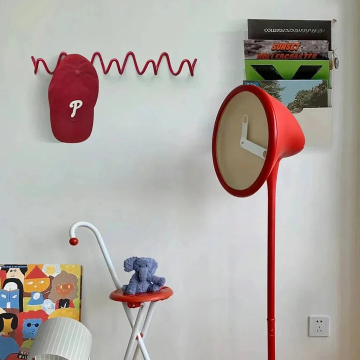 Red wavy wall hook rack with a red baseball cap hanging on it.