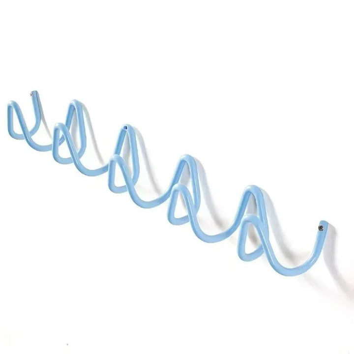 A light blue, wavy wrought iron wall hook rack with multiple hooks.