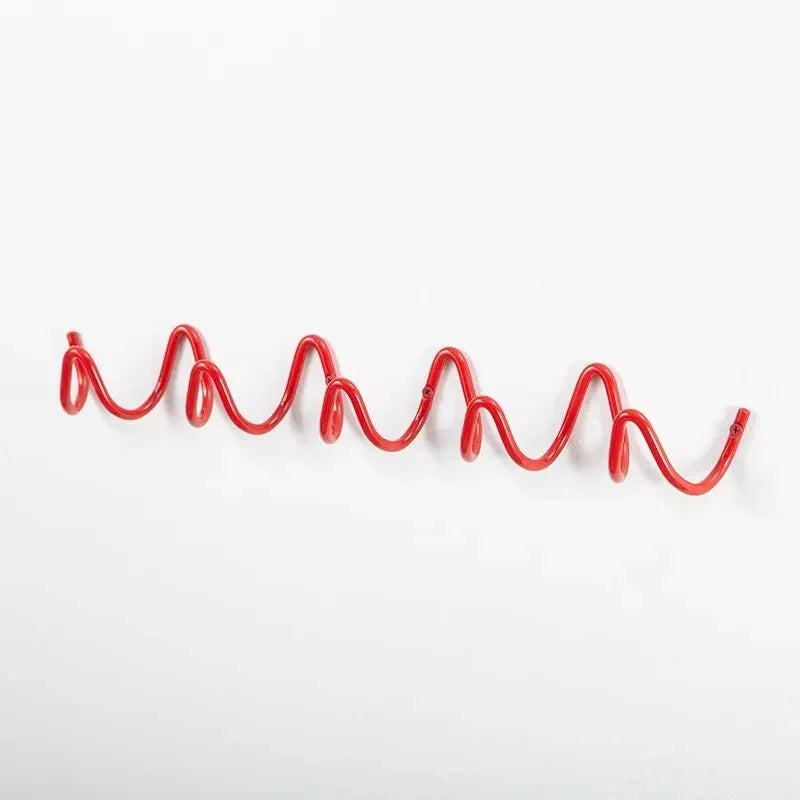 Red wavy wrought iron wall hook rack with multiple loops for hanging items.