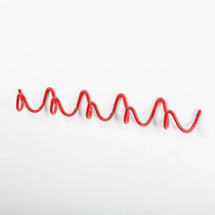 Red wavy wrought iron wall hook rack with multiple loops for hanging items.