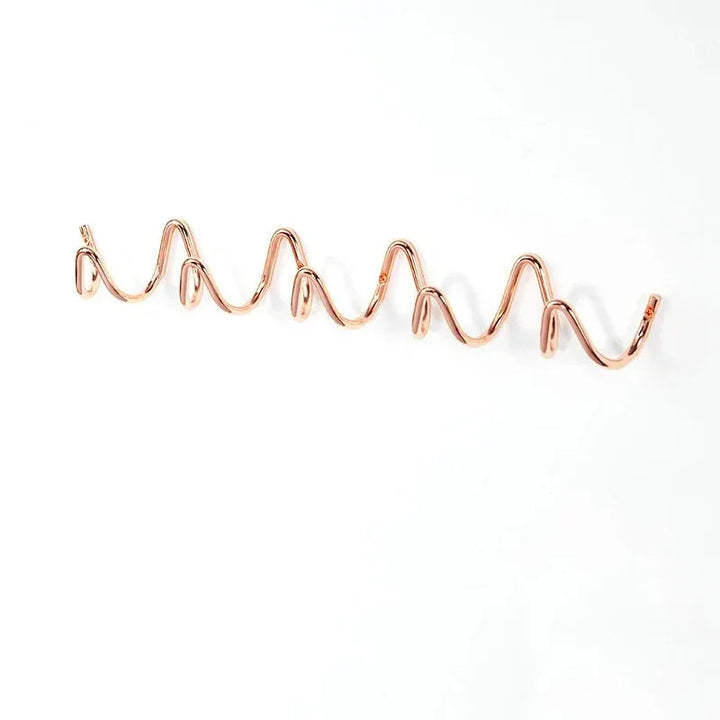Rose gold wavy wall hook rack with multiple hooks.