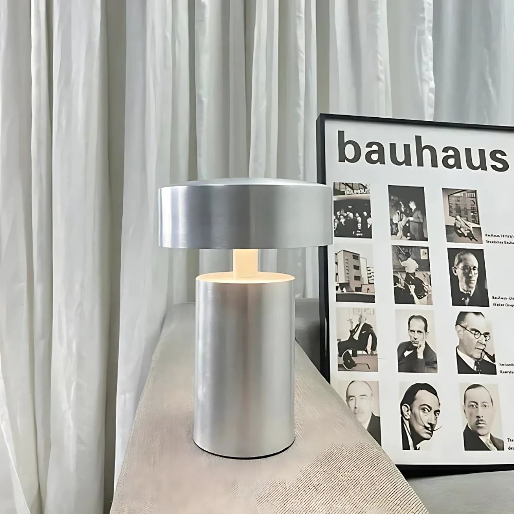 Modern silver column LED table lamp with a minimalist design, casting a soft ambient glow.