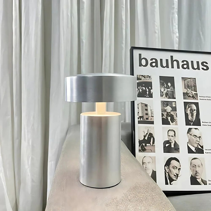 Modern silver column LED table lamp with a minimalist design, casting a soft ambient glow.