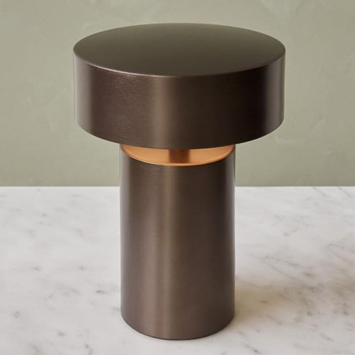 Dark bronze cylindrical table lamp with a wider, flat top and a copper accent ring.