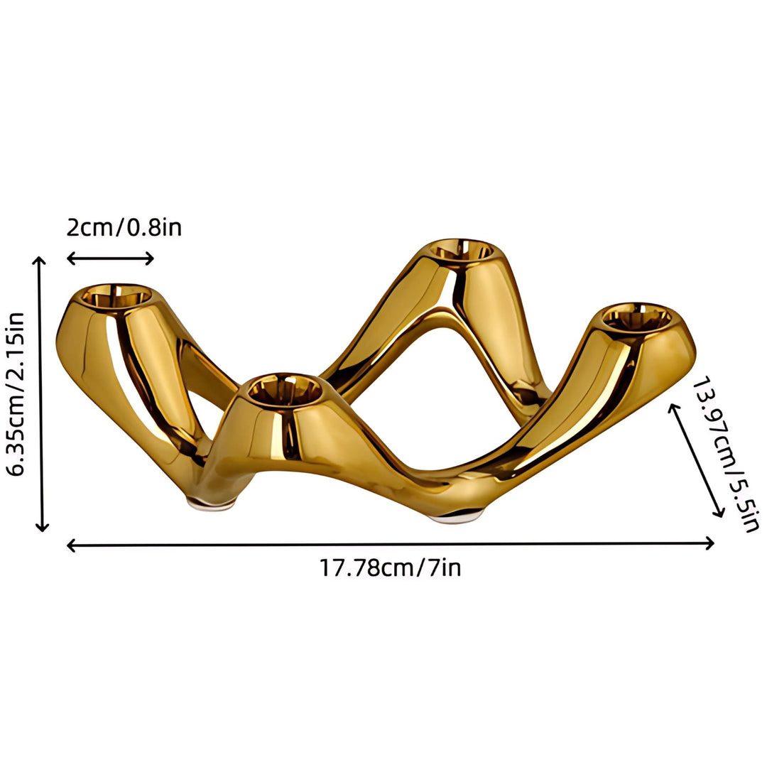 Gold ceramic candle holder with a wavy, sculptural design and four candle cups. Dimensions: 17.78cm/7in long, 6.35cm/2.15in high, 13.97cm/5.5in wide.