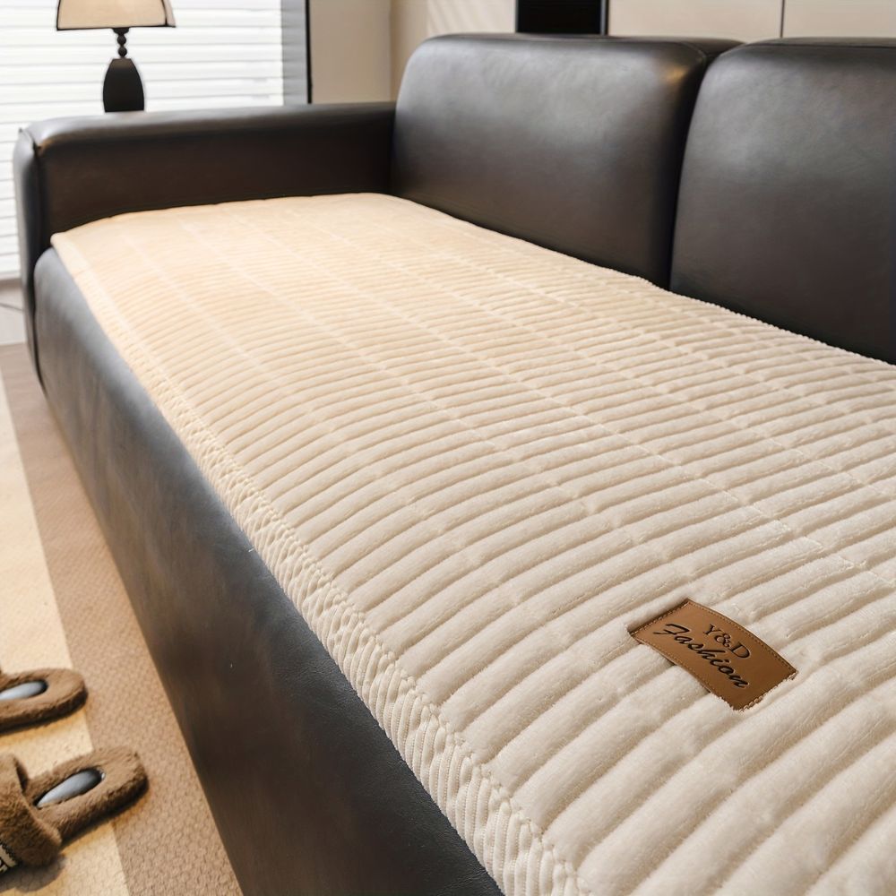 Cream quilted microfiber couch cushion protector with a brown &