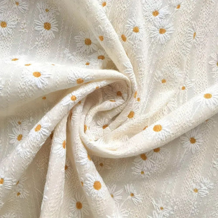 White cotton cabinet curtain with embroidered white daisies and yellow centers.