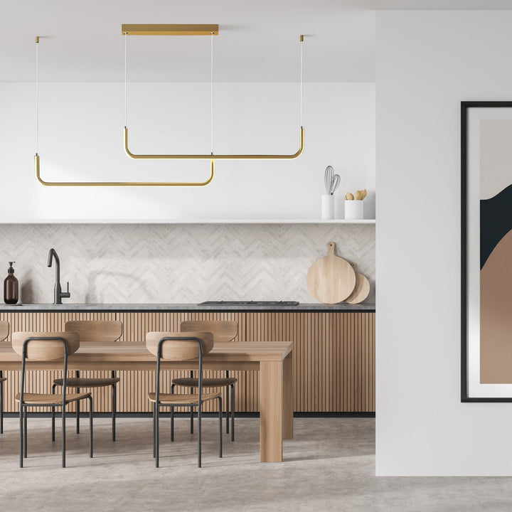 Modern gold adjustable pendant light over a wooden dining table and kitchen island.