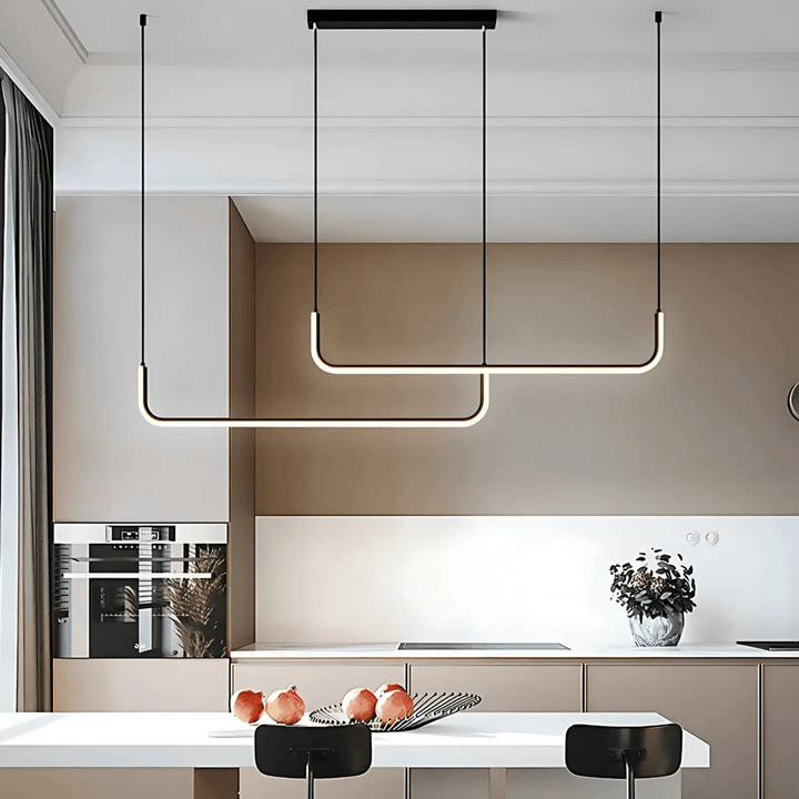 Two modern black adjustable pendant lights with U-shaped LED bars hang over a kitchen island.