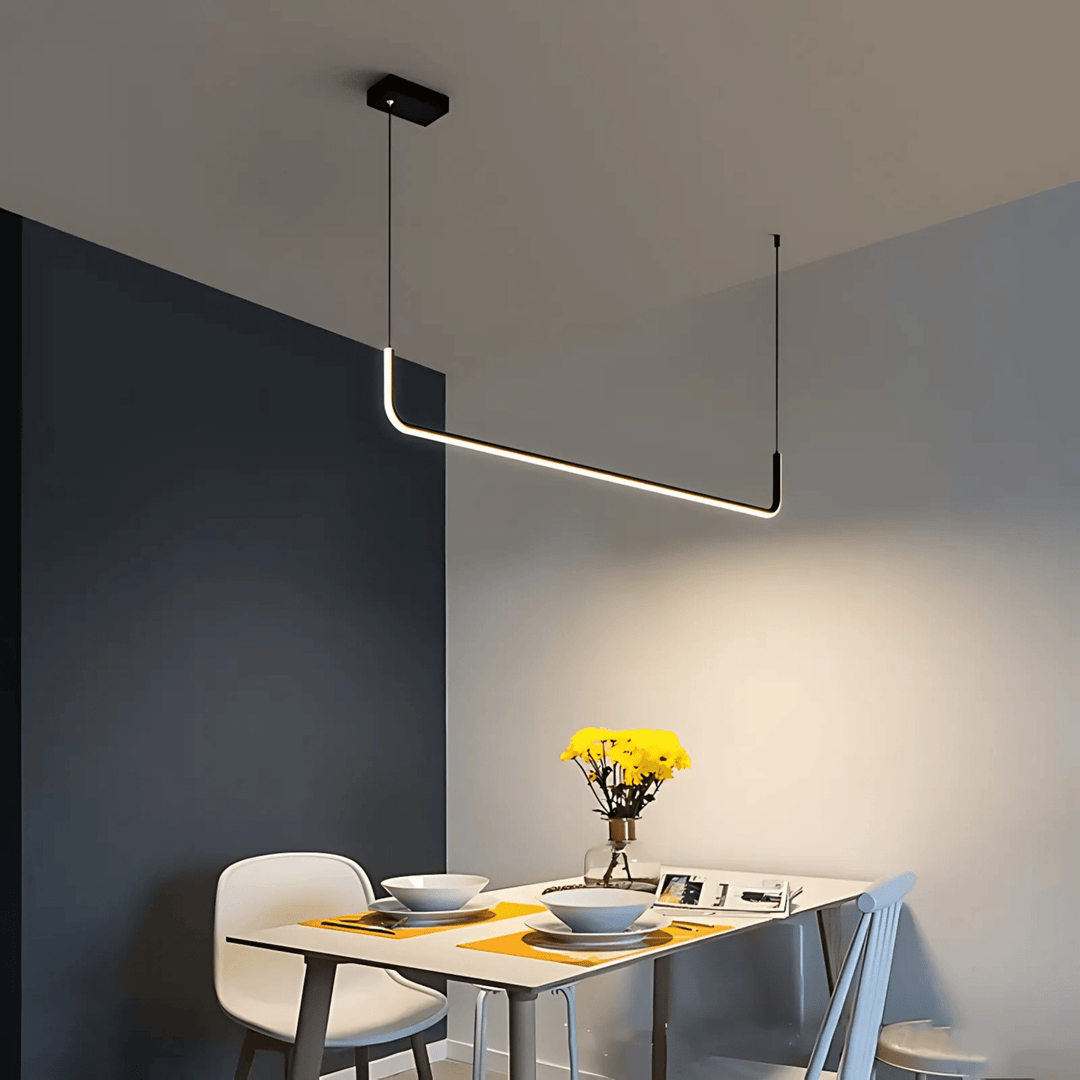 Modern adjustable pendant light with a sleek black frame and integrated LED, suspended over a dining table.