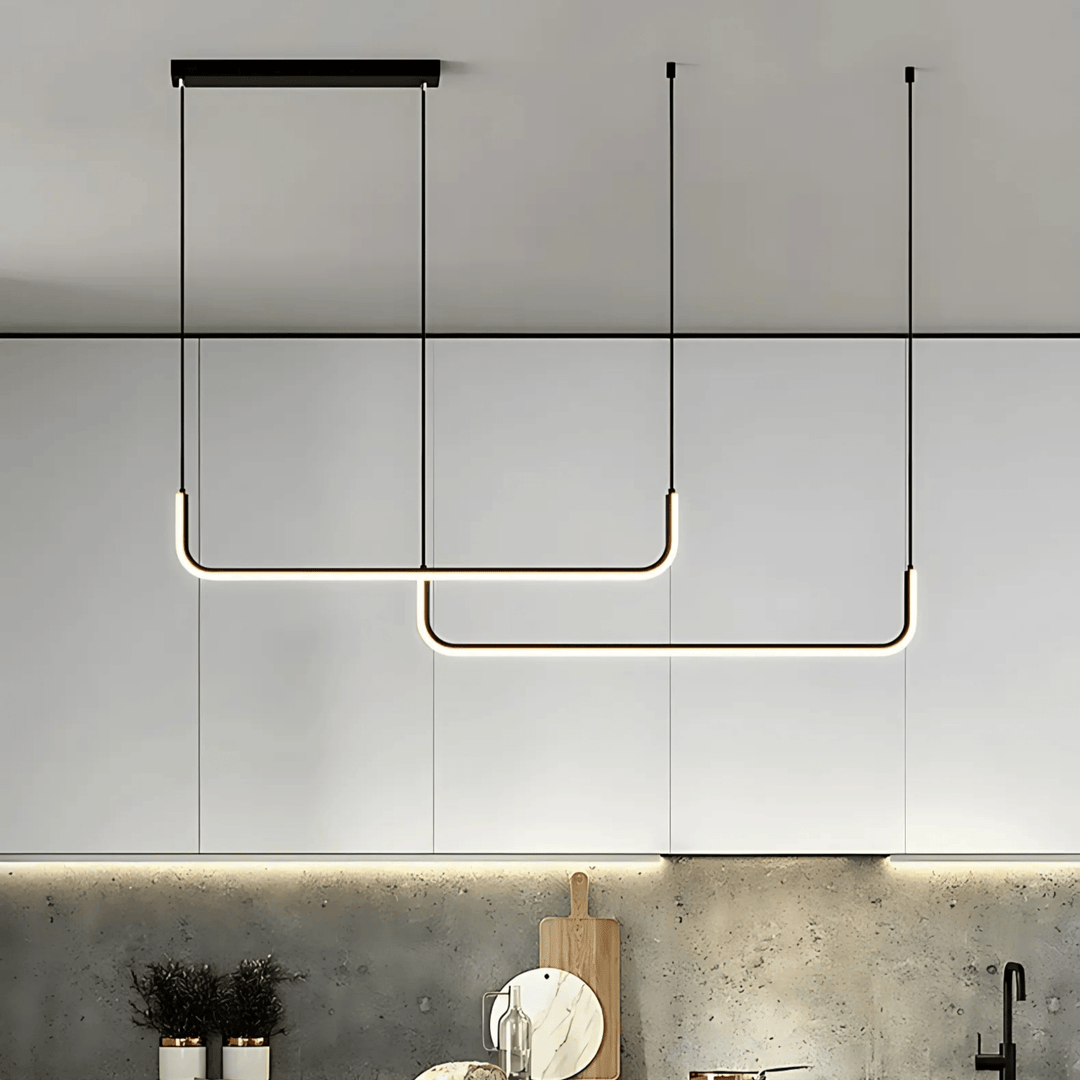 Two modern U-shaped black pendant lights with integrated LED illumination hanging over a kitchen counter.