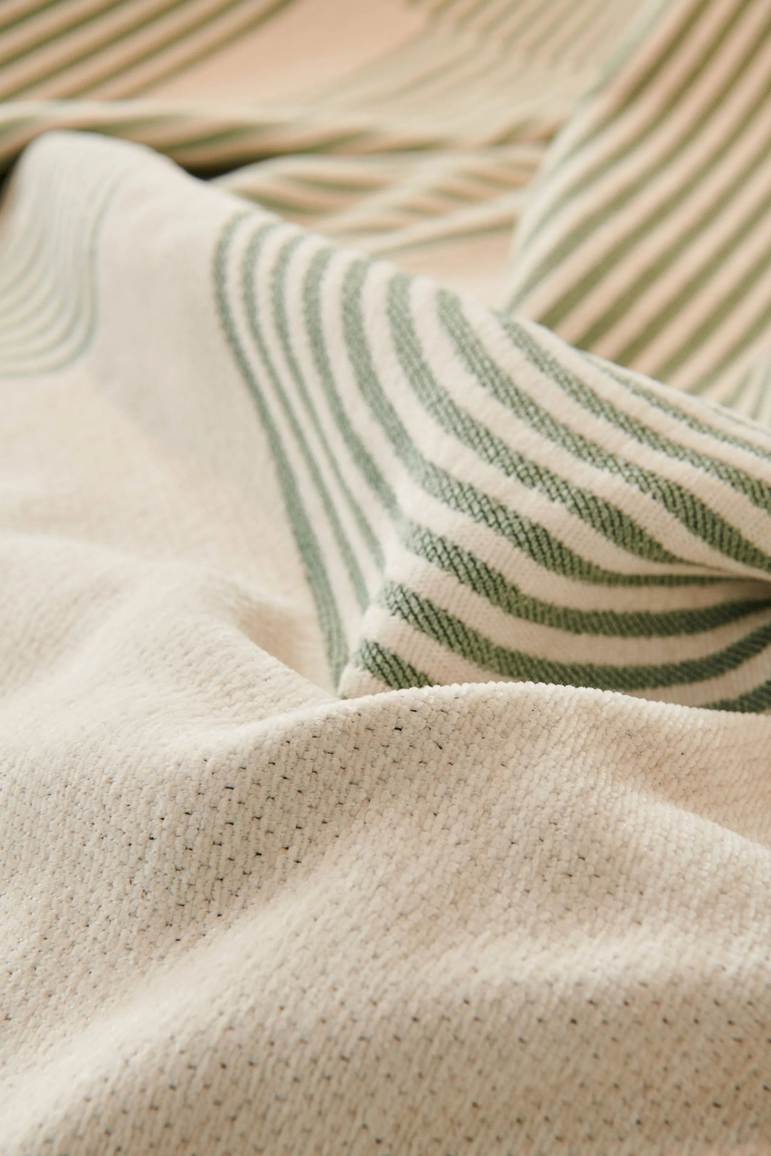 Pistachio green chenille throw blanket with soft texture and subtle stripes.