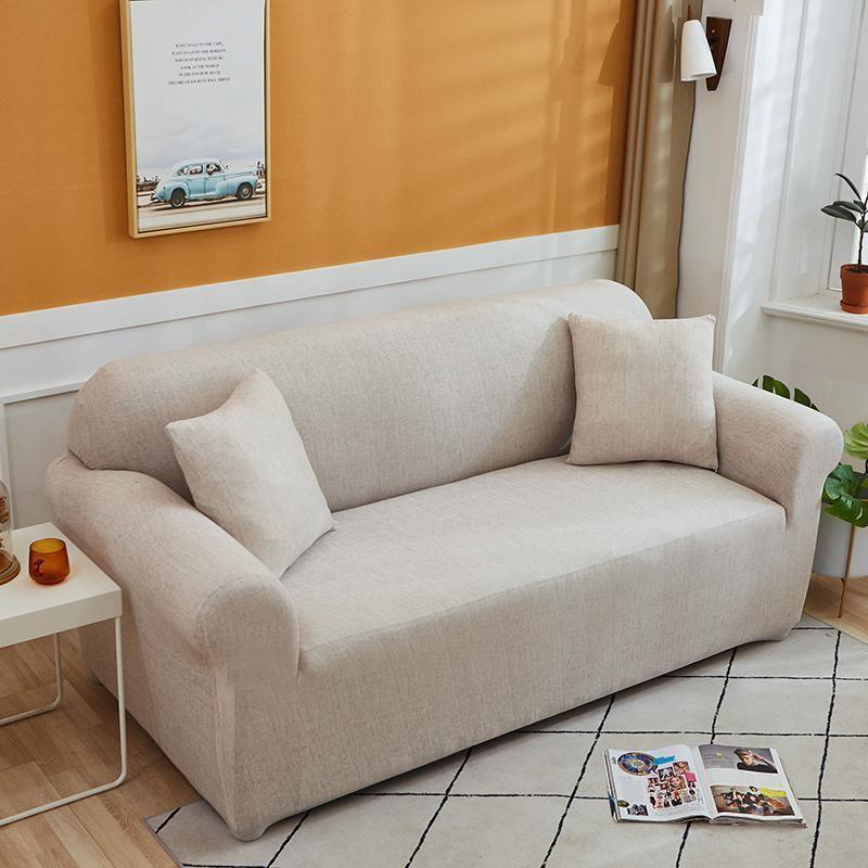 Egg shell colored couch cover with a cross pattern, featuring two throw pillows.